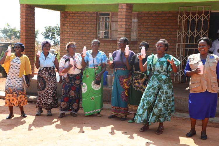 Women of Doroba showcasing yoghurt produced with support from AGCOM 